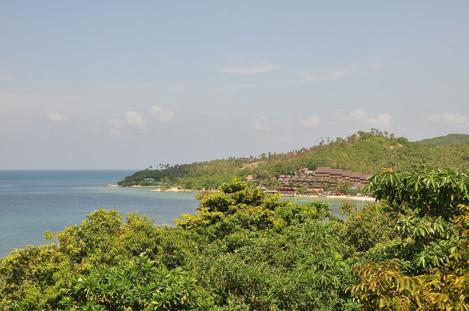 Green headland and calm turquoise sea at Haad Yao beach on the west coast of Koh Phangan