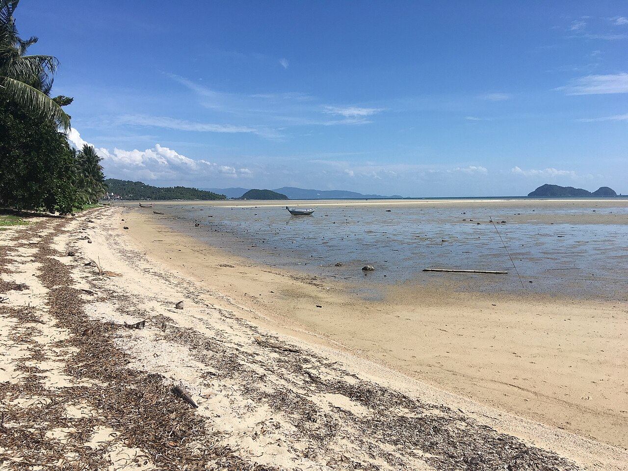 Hin Kong Beach at low tide on the west coast of Koh Phangan, with Koh Samui on the horizon